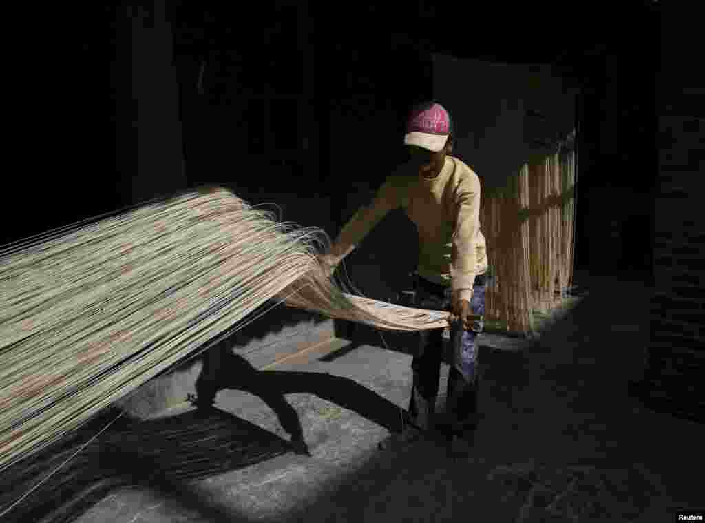 A man dries handmade noodles in the sunlight in Fuxing town, Changhua County, Taiwan.