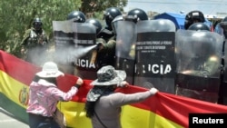 Un policía lanza gases lacrimógenos a un manifestantes que bloquea una carretera en Cochabamba, Bolivia, el 9 de noviembre de 2021.