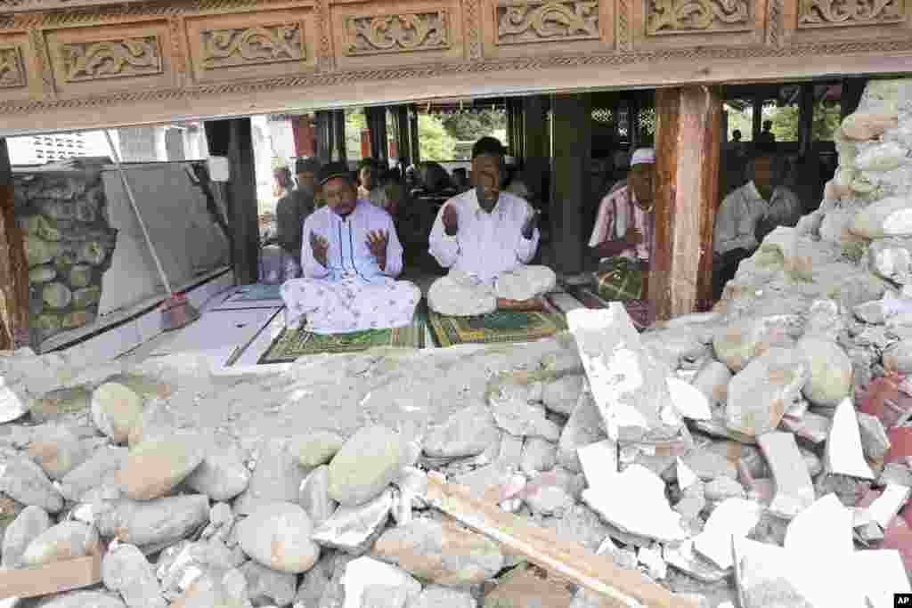 Survivors perform Friday prayer at a mosque badly damaged by Wednesday&#39;s earthquake in Pidie, Aceh province, Indonesia. Over 100 people were killed in the quake that hit the northeast of the province on Sumatra before dawn Wednesday.