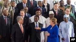 German Chancellor Angela Merkel (Front-R) speaks with United Nations Secretary General Antonio Guterres (Front-L), during a group photo at an EU Africa summit in Abidjan, Ivory Coast on Nov. 29, 2017.