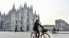 Une personne portant un masque fait du vélo sur la place du Duomo, dans la Lombardie en Italie, après que le gouvernement a introduit de nouvelles mesures restrictives en raison d'une hausse du nombre d'infections par le COVID-19, Italie 19 octobre 2020. REUTERS/Flavio Lo Scalzo