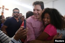 FILE - A woman takes a photo with Fernando Haddad, presidential candidate of Brazil's leftist Workers' Party, after a celebration in Sao Paulo, Brazil, Oct. 12, 2018.