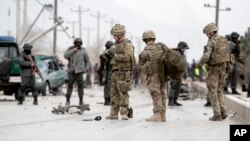 Polisi Afghanistan dan pasukan NATO memeriksa jalan raya antara Jalalabad-Kabul, Afghanistan menyusul insiden ledakan bom bunuh diri dengan menggunakan mobil, yang menewaskan tiga tentara NATO (27/12). 