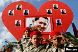ພວກເຍົາວະຊົນໃສ່ເຄື່ອງແບບ ຍົກມືຄຳນັບມື້ລາງທ່ານ Hugo Chavez