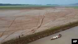 FILE - Fishermen propulsion  a vessel  successful  the Aleixo Lake amid a drought successful  Manaus, Amazonas state, Brazil, Sept. 24, 2024.