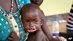 Agiu Nyang, 1, who is sick with measles, sits on the lap of his mother Amel Makir at the hospital in Kuajok, South Sudan, April 16, 2019.