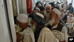 FILE - Afghan refugees living in Pakistan wait to get their documents to travel back to Afghanistan, at the UNHCR's Repatriation Center, in Peshawar, Pakistan, Sept. 7, 2016.