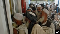 FILE - Afghan refugees living in Pakistan wait to get their documents to travel back to Afghanistan, at the UNHCR's Repatriation Center, in Peshawar, Pakistan, Sept. 7, 2016. Since January 2016, more than 700,000 unregistered Afghans have returned from Pakistan and Iran, up 50,000 on the year before, IOM figures show.