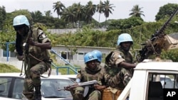 A U.N. soldier jumps out of a pickup truck after security forces loyal to strongman Laurent Gbagbo fired to disperse women protesting for a peaceful solution to the nation's political crisis near the U.N. compound in Abidjan, Mar 3 2011