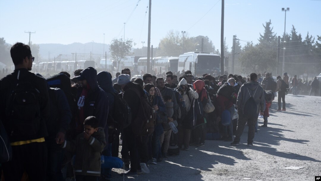 Migrants and refugees wait in a queue to be allowed to pass from the northern Greek village of Idomeni to southern Macedonia, Nov. 9, 2015. 
