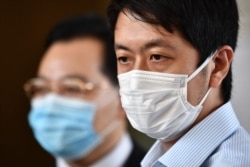 Pro-democracy lawmaker Ted Hui (R) speaks to the media outside the West Kowloon Court in Hong Kong on August 24, 2020.