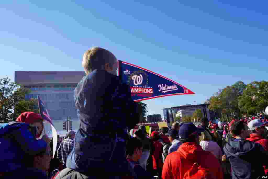 Un niño ondea una de los banderines del equipo local durante el desfile de celebración del sábado en Washington DC.