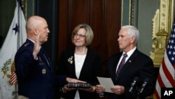 Vice President Mike Pence, right, swears in Air Force General John Raymond as Chief of Space Operations, in his Ceremonial Office in the White House complex, Jan. 14, 2020 in Washington, as his wife, Molly Raymond, looks on.