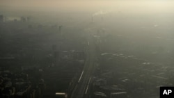 FILE - Pollution haze is seen over southeast London, through a window in a viewing area of the 95-story The Shard skyscraper, Jan. 19, 2017.