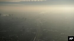 FILE - Pollution haze is seen over southeast London, through a window in a viewing area of the 95-story The Shard skyscraper, Jan. 19, 2017.