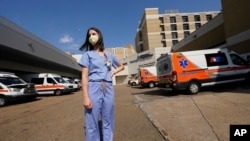 Anne Sinclair, a pediatric emergency room nurse at the University of Mississippi Medical Center, in Jackson, stands in the middle of the filled ambulance bay, Aug. 25, 2021.