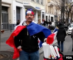 Moroccan Mustapha el-adkour selling flags near Place de la Republique, Jan. 10, 2016. (Lisa Bryant/VOA)