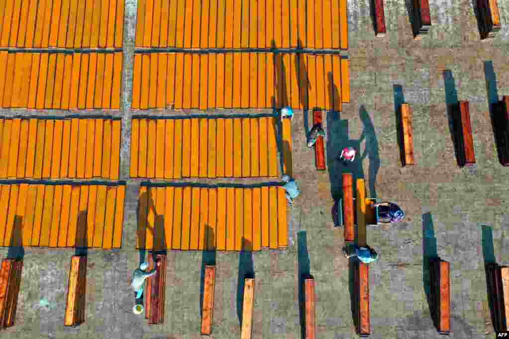 Syrian youths from the eastern Ghouta region on the outskirts of Damascus prepare strips of dried apricot paste, for making the Qamar al-Din drink their region is famous for producing, in Binnish in Syria&#39;s rebel-held northwestern province of Idlib.