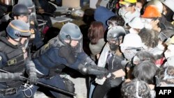 La policía realiza un arresto mientras se enfrenta a estudiantes pro-palestinos después de desmontar parte de la barricada del campamento en el campus de la Universidad de California, Los Ángeles (UCLA), la madrugada del 2 de mayo de 2024.