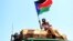A man waves a South Sudanese flag as he celebrates referendum results in the town of Abyei, Oct. 31, 2013. 