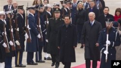 Chinese President Hu Jintao and U.S. Vice President Joe Biden walk the red carpet upon the president's arrival, Tuesday, Jan. 18, 2011, at Andrews Air Force Base, Md.