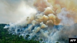 (FILES) In this file photo taken on August 16, 2020, aerial view of a burning area of Amazon rainforest reserve, south of Novo Progresso in Para state, Brazil. - Rampant fires in the Amazon are "poisoning the air" of the world's biggest rainforest,…