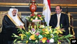In this picture provided by the office of the Egyptian Presidency, Egyptian President Abdel-Fattah el-Sissi, right, sits with Saudi Arabia's King Salman in the Abdeen Palace, Cairo, April 9, 2016.