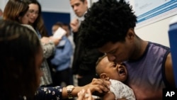 Un trabajador de salud vacuna a un bebé contra el sarampión en Río de Janeiro, Brasil. Las autoridades de salud brasileñas lanzan una campaña nacional de vacunación contra el sarampión y la poliomielitis, dos enfermedades que aparecen en mayor número en América Latina.