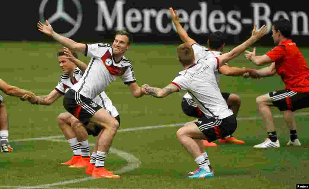 Parece uma dança, mas é um exercício de aquecimento da selecção alemã. Em destaque na foto estão Marco Reus (à direita) e Kevin Grosskreutz na sessão de treino em St. Martin, norte da Itália, Maio 29, 2014.