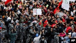 Riot police push back demonstrators near the government palace, during an anti-government protest organized by the country's communist party, in Beirut, Lebanon, Dec. 16, 2018.