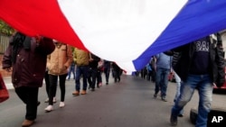 ARCHIVO - Manifestantes llevan una bandera paraguaya en una protesta contra el gobierno, el 12 de agosto de 2021. 