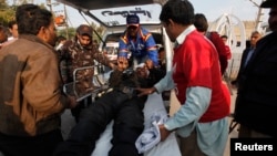 After a deadly bomb blast on a bus, rescue workers move an injured policeman on a stretcher, outside Jinnah Postgraduate Medical Centre Hospital in Karachi, Feb. 13, 2014.