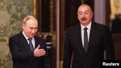 Presiden Rusia Vladimir Putin dan Presiden Azerbaijan Ilham Aliyev memasuki aula selama pertemuan di sela-sela pertemuan puncak para pemimpin negara anggota Persemakmuran Negara-negara Merdeka (CIS) di Kremlin, Moskow, Rusia, 8 Oktober 2024. (Foto: via Reuters)