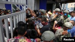 Soldiers control the access to the Gamarra textile market after Peru's government deployed military personnel to block major roads, as the country rolled out a 15-day state of emergency to slow the spread of coronavirus disease (COVID-19), in Lima,…