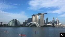 Kayaks are dwarfed against the skyline of the Marina Bay, which is home to popular hotels, and tourist attractions, March 21, 2017, in Singapore.