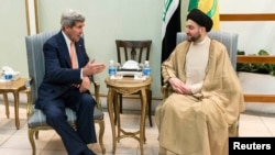 Ammar al-Hakim, pimpinan ISCI (Islamic Supreme Council of Iraq) saat bertemu dengan Menlu AS John Kerry (kiri) di Baghdad (23/6).