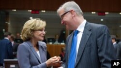 Spain's Finance Minister Elena Salgado, left, talks with European Commissioner for the Economy Olli Rehn at the start of an EU Finance Ministers meeting at the EU Council in Brussels, November 8, 2011.