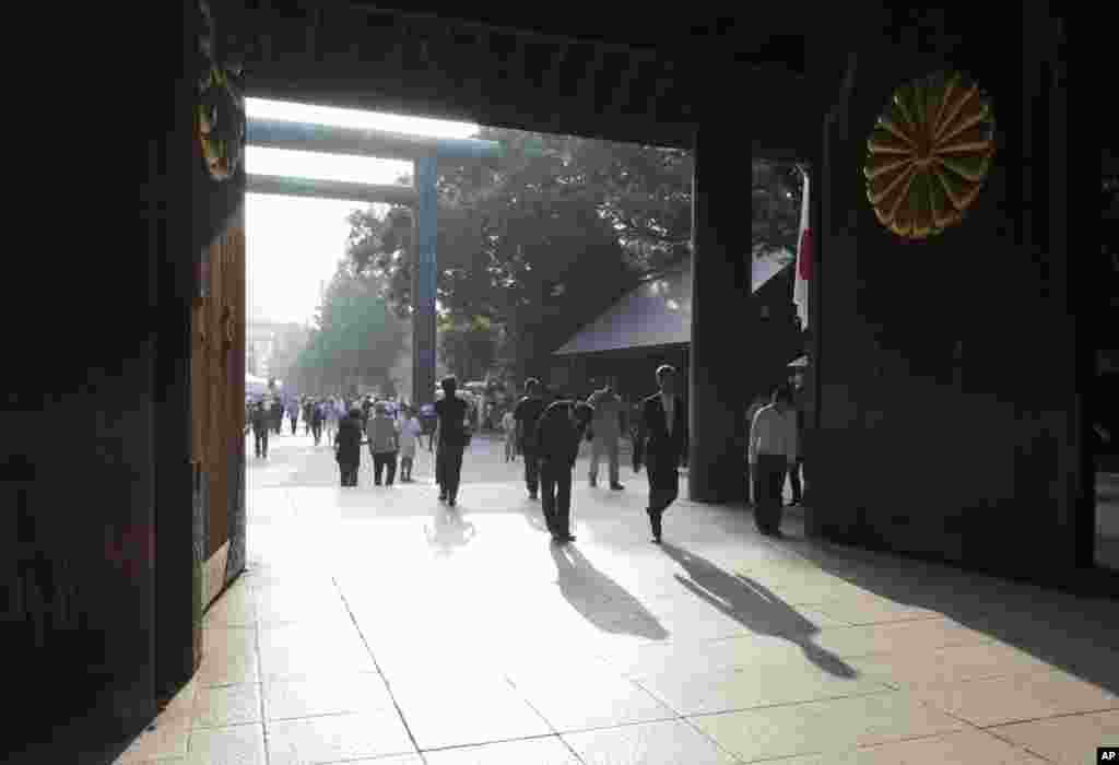People bow at the Yasukuni Shrine in Tokyo, August 15, 2013.
