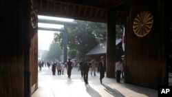 People bow at the Yasukuni Shrine in Tokyo, Aug. 15, 2013.