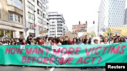 Personas participan en una Marcha por el Clima antes de la cumbre climática COP26, en Bruselas, el 10 de octubre de 2021.