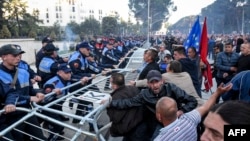 Demonstrators try to remove a metal fence outside a government building during an opposition protest in Tirana, Albania, May 11, 2019.