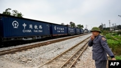 A railway worker guides a train in Hanoi, Vietnam, on Feb. 13, 2025. Vietnam's National Assembly on Feb. 19 approved the use of Chinese loans to build an $8 billion rail link from its largest northern port city to the border with China.