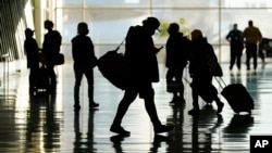 FILE - Passengers walk through Salt Lake City International Airport Tuesday, Oct. 27, 2020, in Salt Lake City. Not as many young adults live far away from where they grew up compared to their parents. (AP Photo/Rick Bowmer)