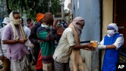 Freira da ordem criada por Madre Teresa distribuindo comida em Calcutá