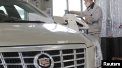 FILE - A staff member works at a service center for repairing Cadillac cars at its dealership in Beijing, China, March 14, 2016.