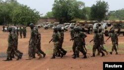 Soldiers from Lagos, part of an expected 1,000 reinforcements sent to Adamawa state to fight Boko Haram Islamists, walk near trucks as they arrive with the 23rd Armoured Brigade in Yola, Nigeria, May 20, 2013.