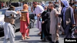 Un miembro de los talibanes apunta con su arma a los manifestantes en Kabul, Afganistán, el 7 de septiembre de 2021.