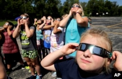 Fourth graders at Clardy Elementary School in Kansas City, Missouri, practice the proper use of their eclipse glasses in anticipation of Monday's solar eclipse, Aug. 18, 2017.