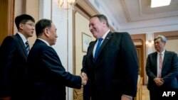 U.S. Secretary of State Mike Pompeo, second from right, greets North Korea's director of the United Front Department, Kim Yong Chol as they arrive for a meeting at the Park Hwa Guest House in Pyongyang, July 6, 2018.