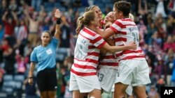 Jugadoras del equipo estadounidense de fútbol celebran el primero gol ante Colombia, a la que derrotaron 3-0, clasificándose así para los cuartos de final.